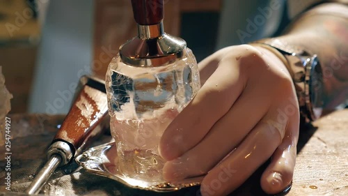 Barman is making brand ice for the cocktail at bar