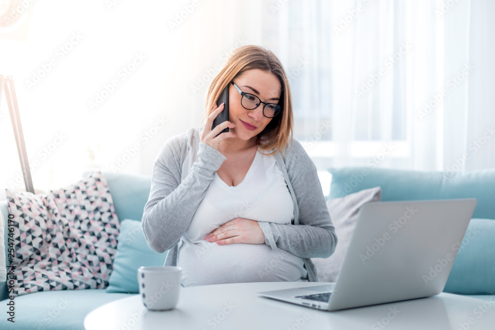 Pregnant woman working online with laptop at home, freelancing concept Pregnant woman working online with laptop at home, freelancing concept