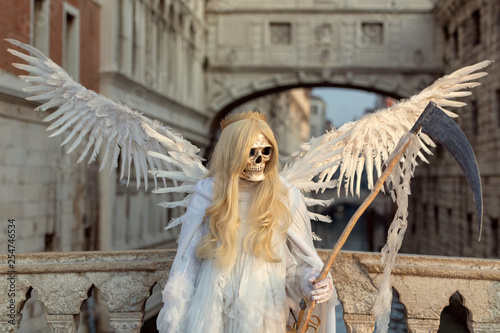 Death angel with skull, scythe and wings in front of Rialto Bridge, Venice photo