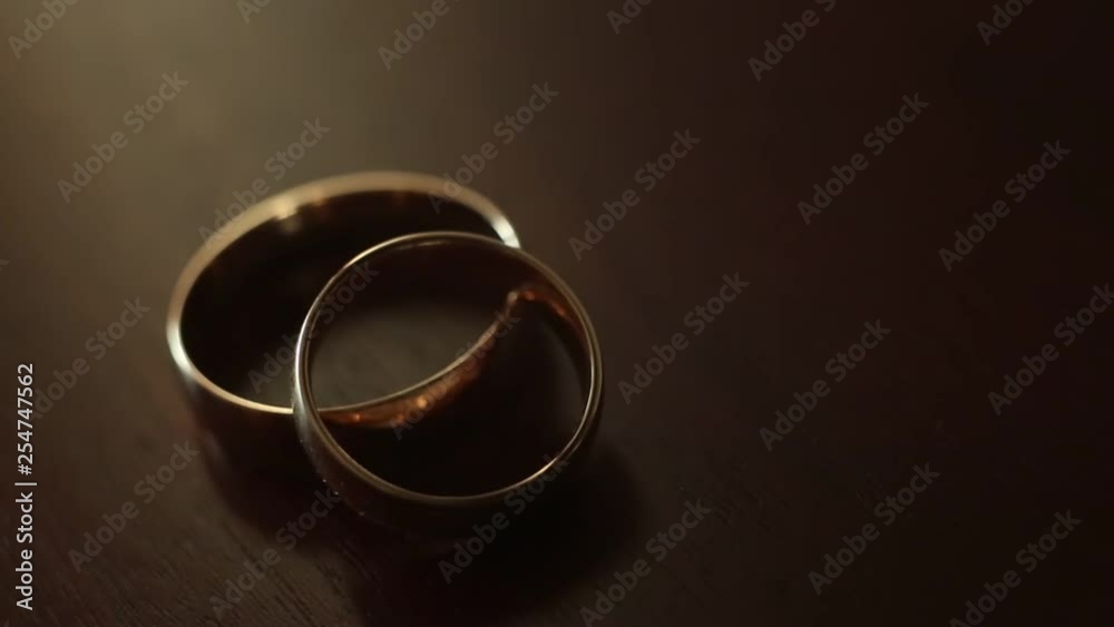 Gold engagement rings on beige background. Wedding Rings. Two splendid wedding rings on a wedding day. Two wedding rings on the table Gold engagement rings on beige background. Wedding Rings. Two splendid wedding rings on a wedding day. Two wedding rings on the table