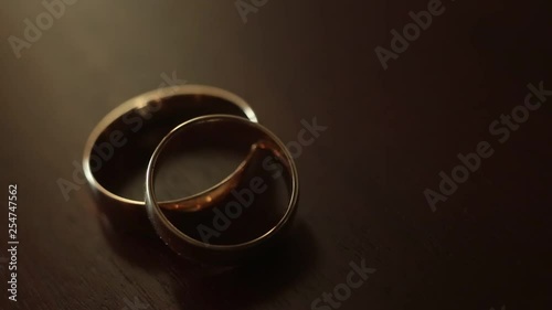 Gold engagement rings on beige background. Wedding Rings. Two splendid wedding rings on a wedding day. Two wedding rings on the table
