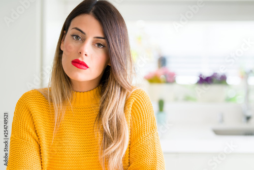 Φωτογραφία Young beautiful woman wearing winter sweater at home with serious expression on face