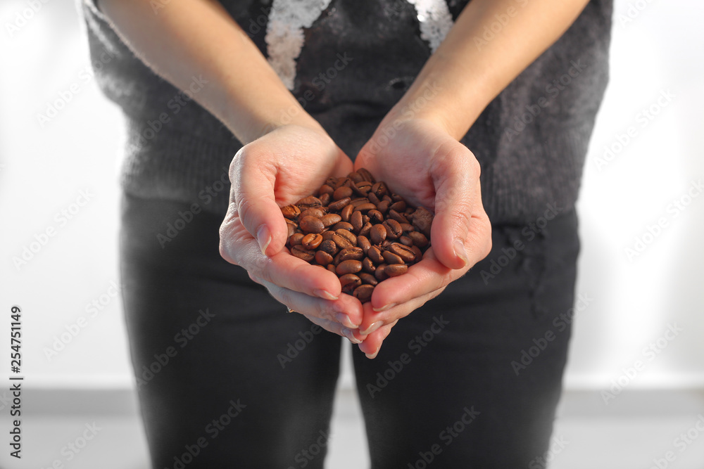 Obraz premium coffee beans in hands on white background