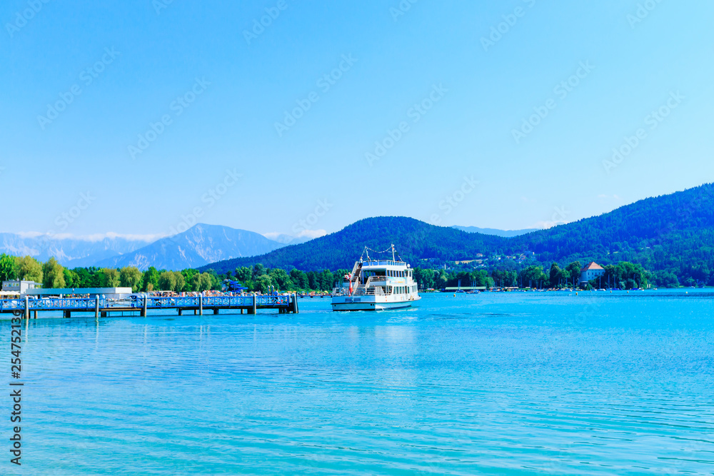 Summer view of the lake and mountain. pier and cruising boat Summer view of the lake and mountain. pier and cruising boat