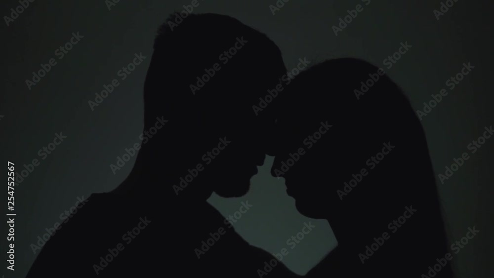 Silhouettes of man and woman. Shadows of men and women on a light background. A man and a woman hug and talk. Slow motion. Silhouettes of man and woman. Shadows of men and women on a light background. A man and a woman hug and talk. Slow motion.