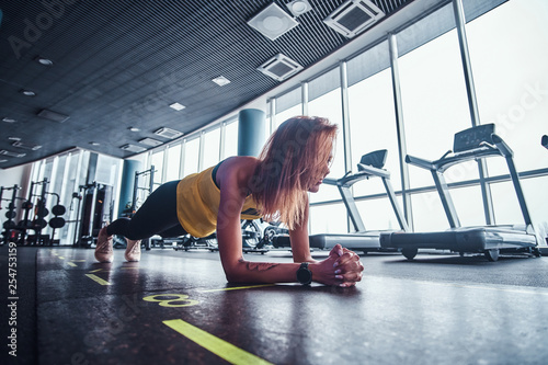 Fitness woman doing the plank in the modern gym. Fashion, sport, motivation