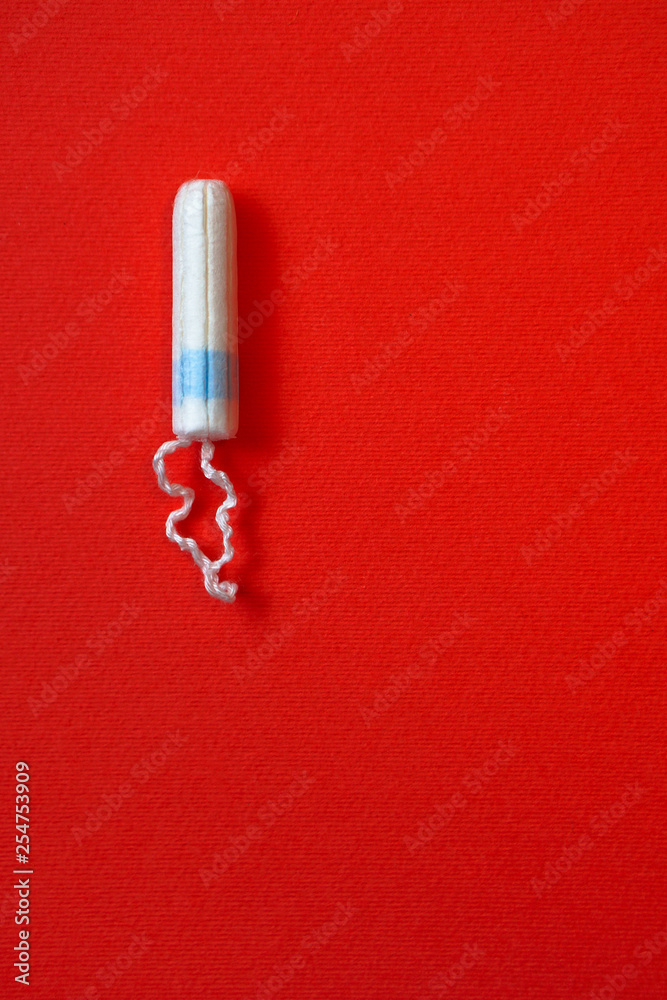 Background red on the theme of a monthly menstrual cycle. PMS and protection against it. Tampon and analgesic tablets. Intimate topic of feminine hygiene. Stock photos Background red on the theme of a monthly menstrual cycle. PMS and protection against it. Tampon and analgesic tablets. Intimate topic of feminine hygiene. Stock photos