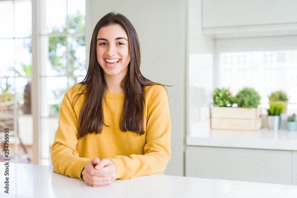 Beautiful young woman wearing yellow sweater with a happy and cool smile on face. Lucky person. Beautiful young woman wearing yellow sweater with a happy and cool smile on face. Lucky person.