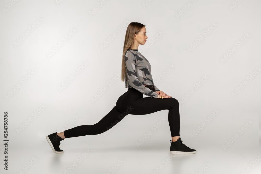 Young sporty attractive woman practicing yoga doing reverse warrior exercise