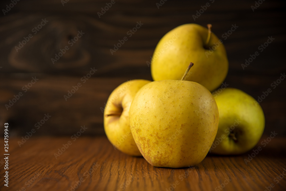 Yellow apple on the wooden vintage background