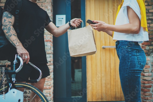 Anonimous bike delivery food service at home. Man courier delivered the order no name bag with food. photo