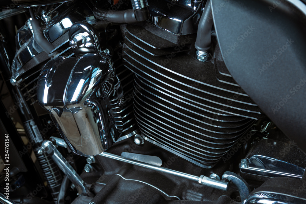 Motorcycle internal combustion engine with air cooling, close-up, detail, macro. Engine parts, cylinder head, ignition, exhaust pipe, air-intake manifold Motorcycle internal combustion engine with air cooling, close-up, detail, macro. Engine parts, cylinder head, ignition, exhaust pipe, air-intake manifold