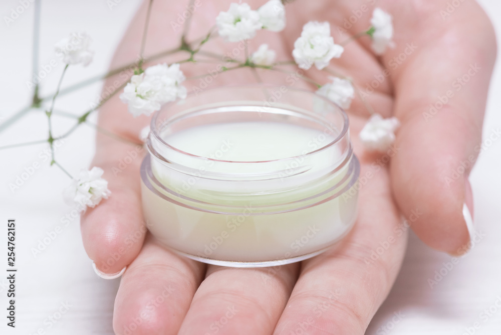Cosmetic natural cream in a jar on a white table background. Cosmetic natural cream in a jar on a white table background.