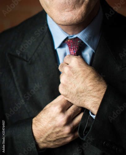 closeup of businessman adjusting tie