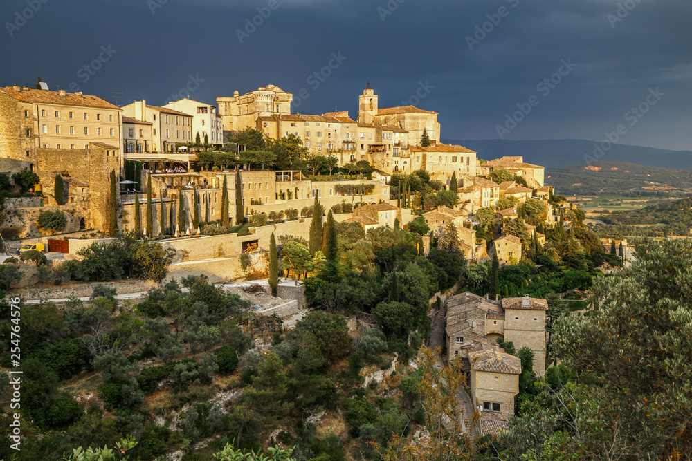 Amazing panoramic view of medieval hilltop village of Gordes before thunderstorm in Provence, France. Travel France.