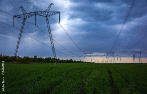  high-voltage power lines at sunset. greeb field.