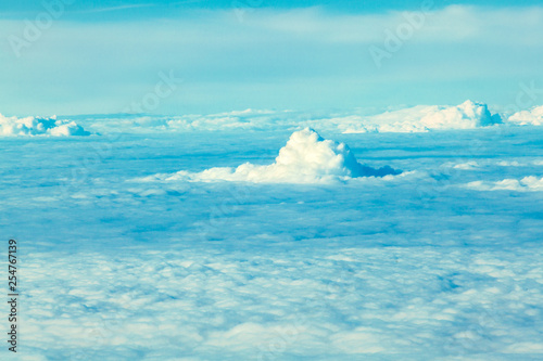 Airplane flying in the blue sky among white clouds