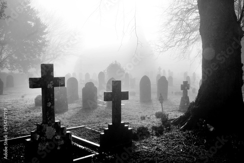 black and white photograph of an English grave yard covered in thick fog photo