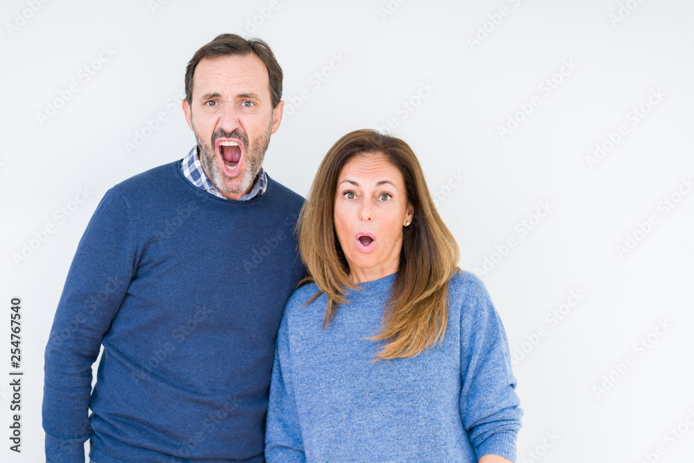Beautiful middle age couple in love over isolated background In shock face, looking skeptical and sarcastic, surprised with open mouth Beautiful middle age couple in love over isolated background In shock face, looking skeptical and sarcastic, surprised with open mouth