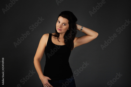 Natural beauty concept. Portrait of young attractive smiling woman. Beautiful sporty lady in black top and blue jeans