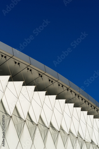 modern building, abstract facade made from aluminum and fabric, blue sky on a sunny day
