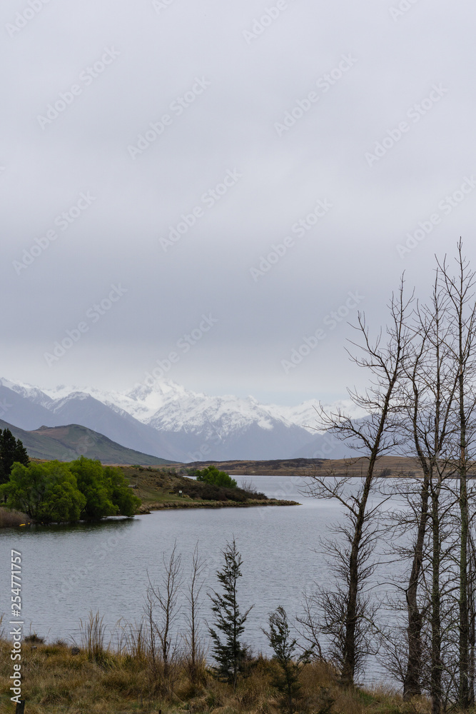 lake in the mountains, foggy weather, mountains on the horizon covered by snow