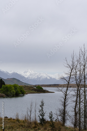 lake in the mountains, foggy weather, mountains on the horizon covered by snow
