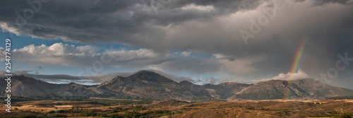 Mountain landscape with a stormy sky and a rainbow