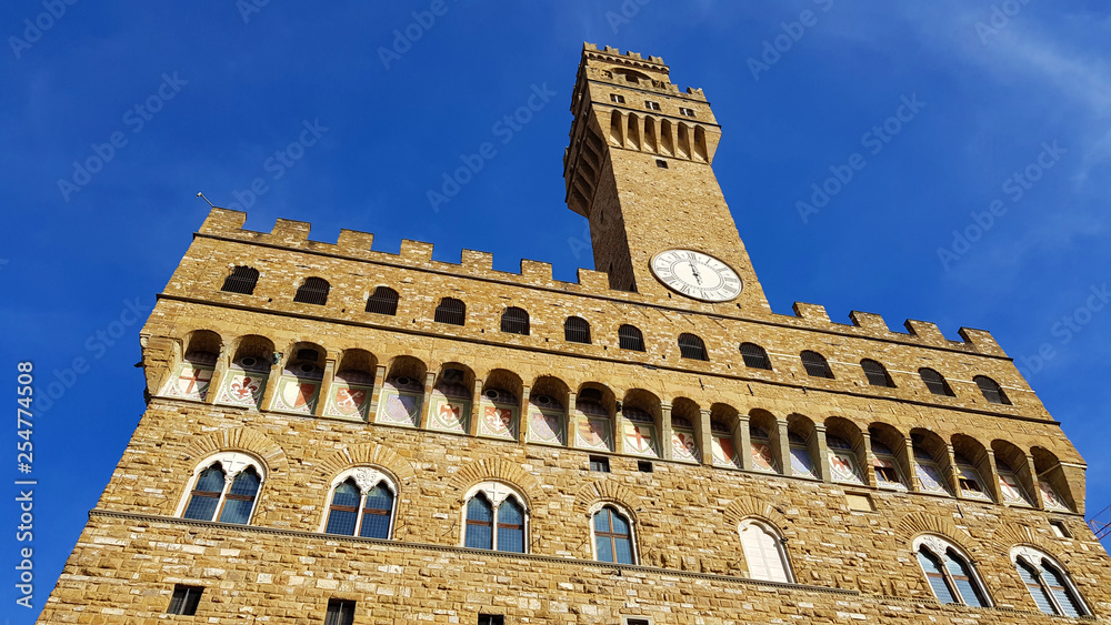 View of the facade of Palazzo Vecchio, Florence, Tuscany, Italy. Upper part of the facade with the tower of Arnolfo