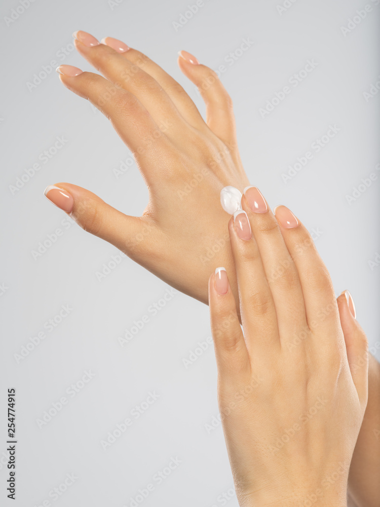 Woman applies a cosmetic moisturizer on her hands. Woman applies a cosmetic moisturizer on her hands.