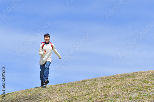 青空で走る小学生の女の子（ランドセル） © hanapon1002