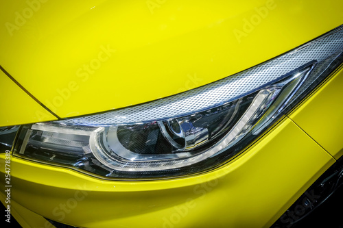 Close-up LED xenon headlight of yellow modern car with halogen lamp technology for illuminate both day and night.