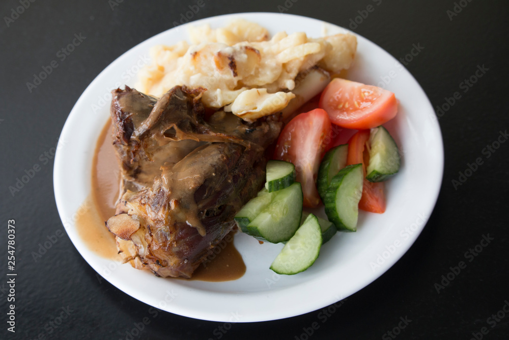 Plate with local lamb dish in Iceland, Potatoes, cucumber, tomatoes Plate with local lamb dish in Iceland, Potatoes, cucumber, tomatoes