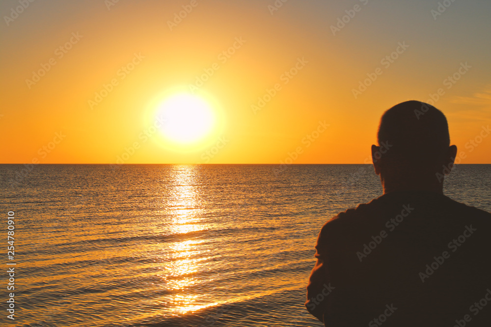An old man sits by the sea and watches the sunset. Background. Texture.