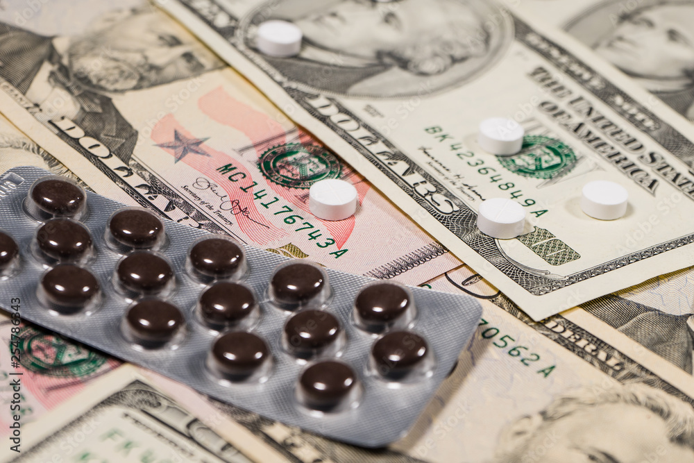 Fototapeta premium High Angle View on Dollars and medicine painkiller pills Health Costs