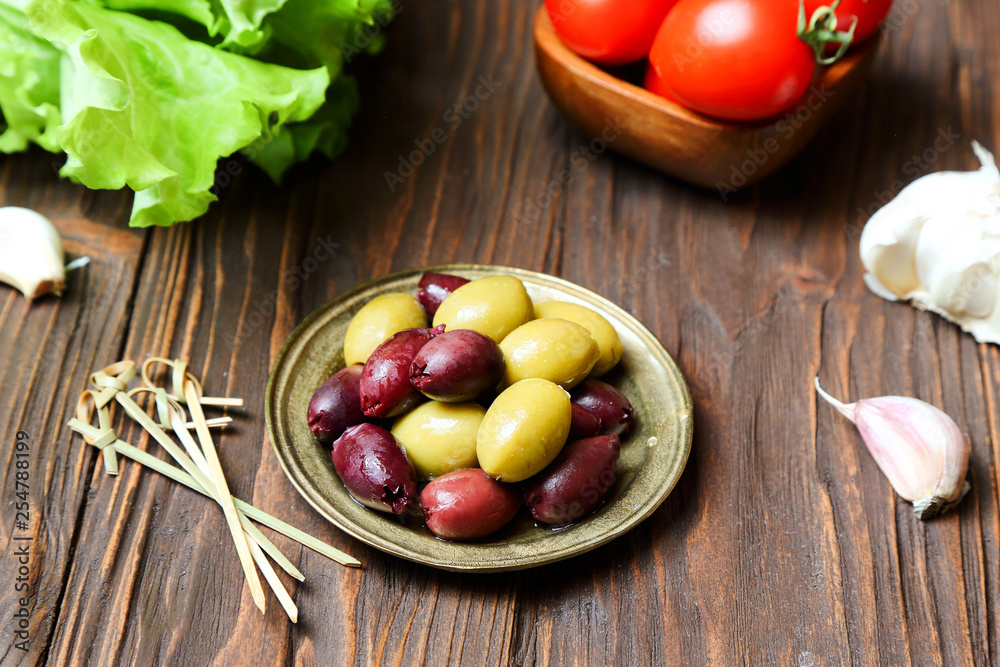 Olives in a bronze plate on the kitchen table Olives in a bronze plate on the kitchen table