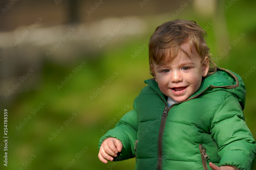 Happy baby with coat and hat in cold sunny weather. Happy baby with coat and hat in cold sunny weather.