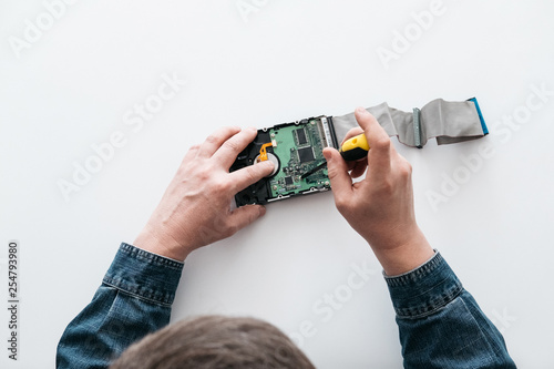 Hard disk recovery service, hands of repairman holding broken hdd with bad sectors. Computer engineer performs urgent repairs recovery of lost data during deletion HDD photo