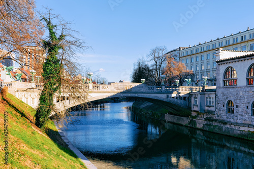 Dragon statue bridge above Ljubljanica River and cityscape in Ljubljana