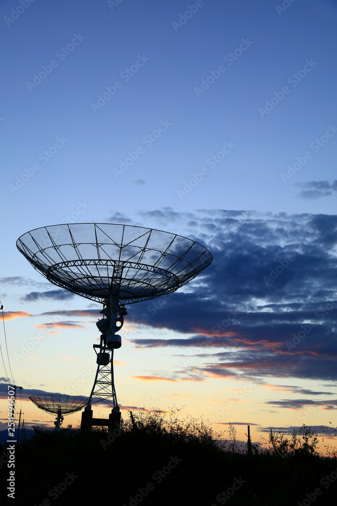 The silhouette of a radio telescope