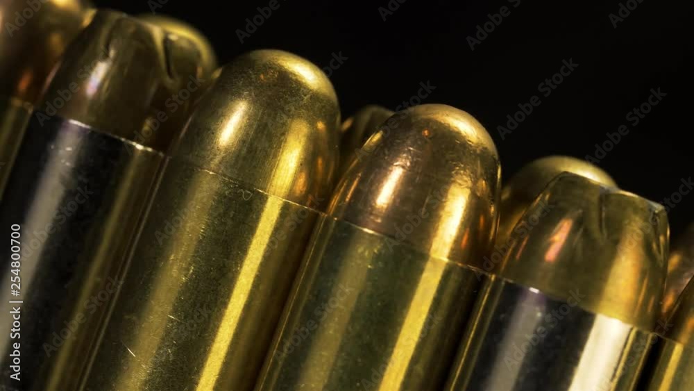 Macro of an assortment of pistol ammunition traveling angled and left across screen. Macro of an assortment of pistol ammunition traveling angled and left across screen.