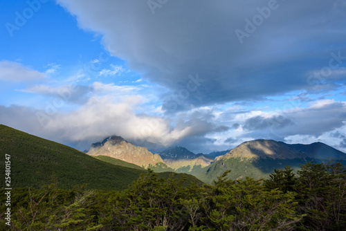 Dramatic scenic view, cloudy sky and early evening sun highlighting mountain peaks, Cerro Alarken Nature Reserve, Ushuaia, Argentina