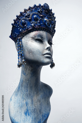 Head of woman mannequin in blue decorated kokoshnick, grey studio background