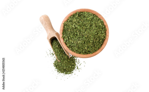 coriander leaves in wooden bowl and scoop isolated on white background. top view. Spices and food ingredients.