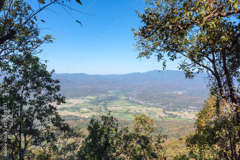 Landscape nature of rice field and small town valley in middle hill and trees in foreground with blue sky background. Landscape nature of rice field and small town valley in middle hill and trees in foreground with blue sky background.