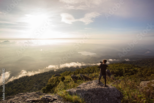 Silhouette man taking photo on top of a Mountain. © nidsornkul1989