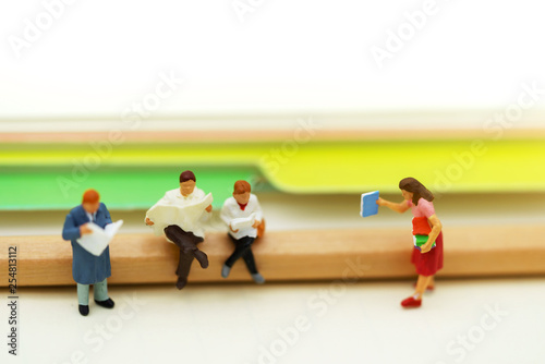 Miniature people: Business team reading book, education or business concept.
