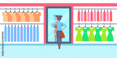 girl trying on new dress elegant woman looking at mirror fashion shop female clothes market modern shopping mall interior flat horizontal full length flat
