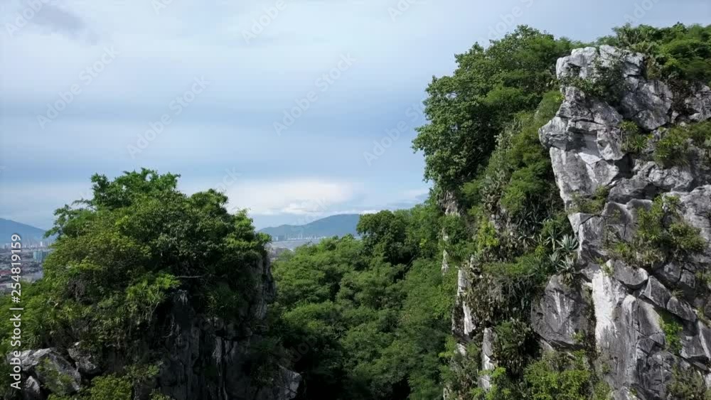 Breathtaking drone shot flying over gorgeous the mountain sides to reveal a city in the background in Laos. Breathtaking drone shot flying over gorgeous the mountain sides to reveal a city in the background in Laos.