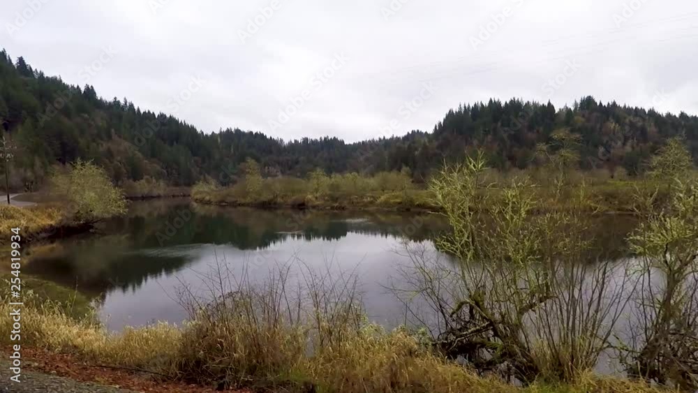 Driving next to a beautiful river with tree covered mountains reflecting in the water in Oregon. Driving next to a beautiful river with tree covered mountains reflecting in the water in Oregon.